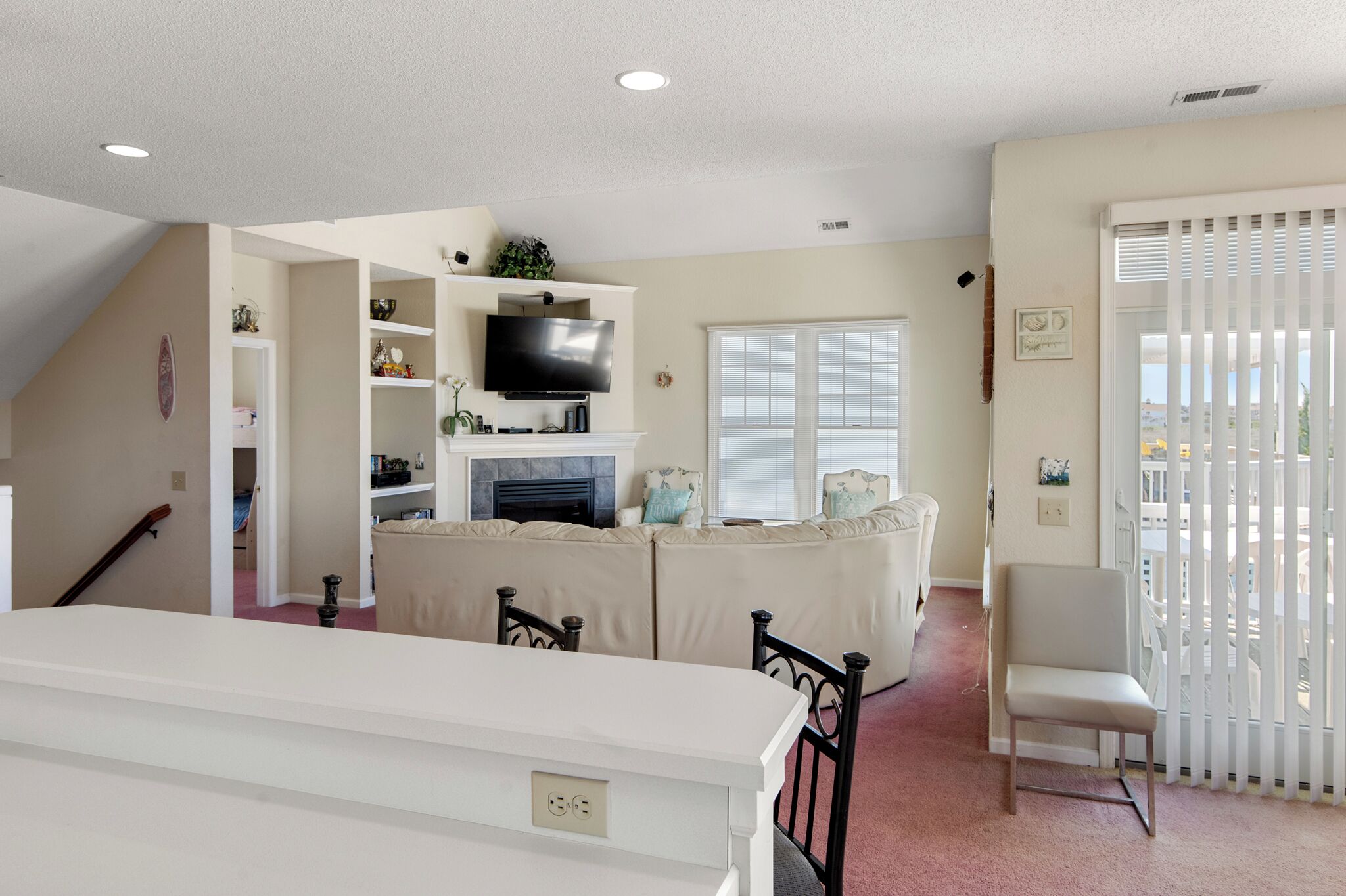 A living room with a fireplace, a television, and a dining area with a table and chairs.