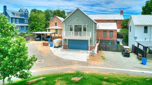 A residential area with a mix of single and multi-story houses, a covered garage, and a driveway leading to a gated entrance. - Carlton Landing-Carriage House (Carlton Landing)