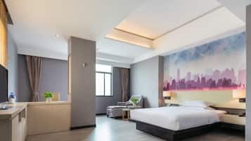 A modern hotel room with a large bed, a desk, a chair, and a cityscape mural on the wall.