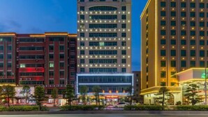 A multi-story hotel with a modern design, featuring a prominent glass facade and a series of balconies. - Caiyang Hotel (Haifeng)