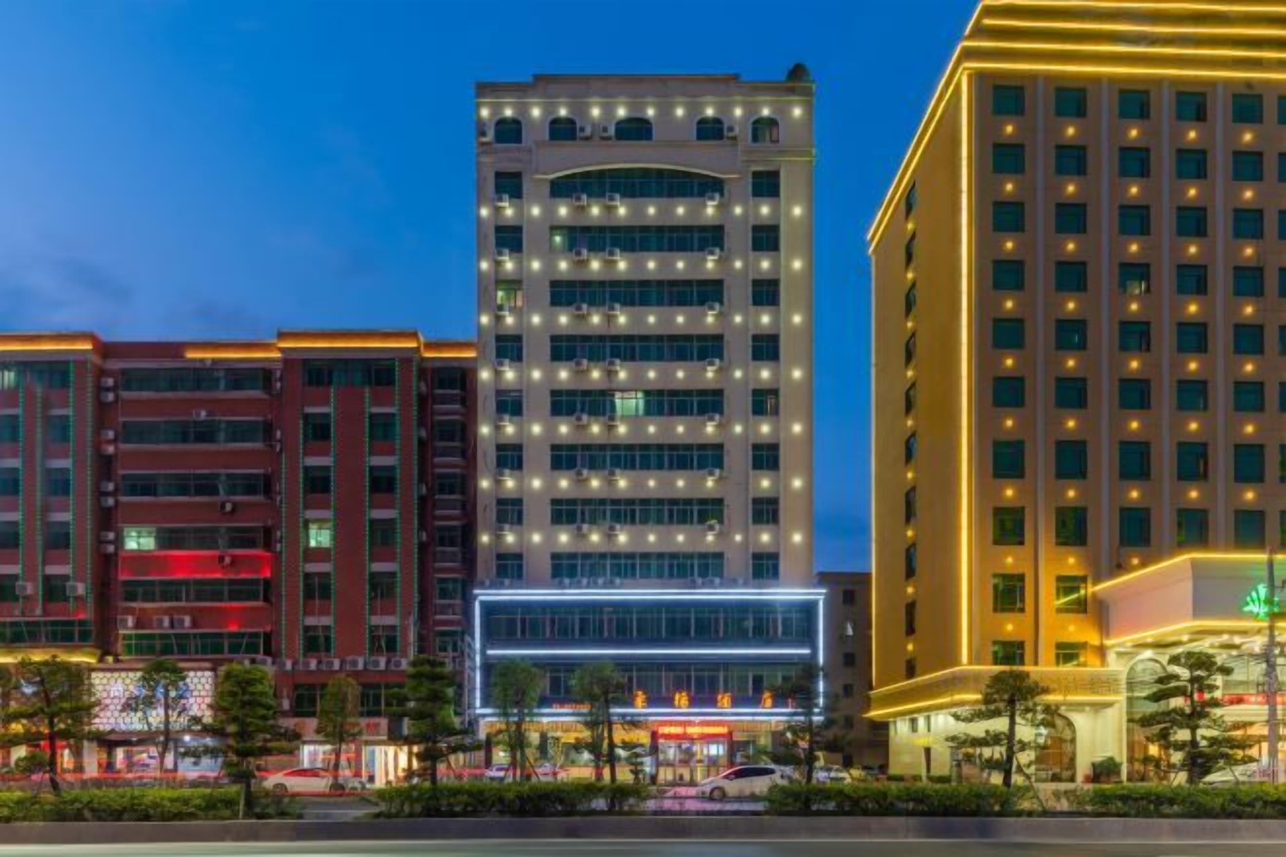 A multi-story hotel with a modern design, featuring a prominent glass facade and a series of balconies.