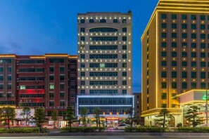 A multi-story hotel with a modern design, featuring a prominent glass facade and a series of balconies. - Caiyang Hotel (Haifeng)