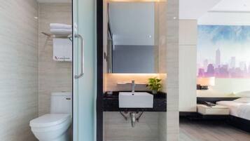 A modern bathroom with a toilet, sink, and shower.