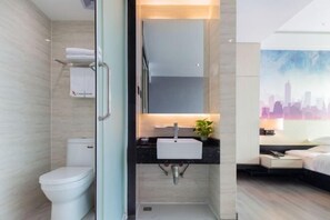 A modern bathroom with a toilet, sink, and shower. - Caiyang Hotel (Haifeng)