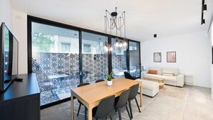 Un salon moderne comprenant un canapé, une table basse et un coin repas avec une table et des chaises.