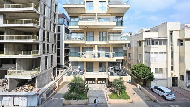 A multi-story residential building with balconies, a covered outdoor area, and a parking space. - Mamma Mia 3BR in Frishman beach by HolyGuest (Tel Aviv-Yafo)