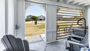 Un área de estar al aire libre con techo, sillones Adirondack y un pérgola de madera.