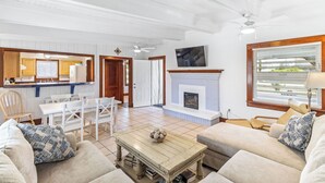 Amplia sala de estar con chimenea, comedor y cocina.