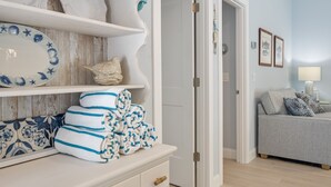 A room with a white dresser, a grey sofa, and a door leading to another room. - Beautiful villa with Private Pool, short stroll to beach w/ beach gear and grill (Holmes Beach)