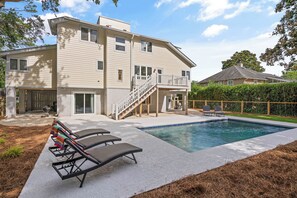 A two-story house with a swimming pool, a covered patio, and a fenced backyard. - You Had Me At SSI, Cute Hideaway with a Pool, sleeps 9 (St Simons Island)
