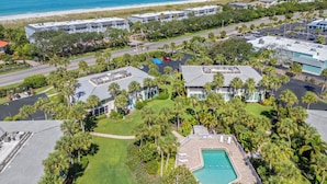 Un complexe hôtelier comprenant plusieurs bâtiments, une piscine et offrant une vue sur la plage.