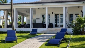 Un'area esterna coperta con un vialetto che conduce a una zona relax con sedie blu.