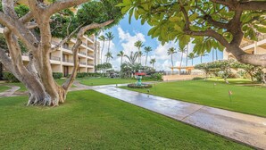 A well-maintained hotel courtyard with a central fountain, palm trees, and a clear sky. - Sugar Beach Resort, #235 1 Bedroom Condo by RedAwning (Kihei)