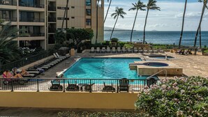 A hotel pool area with multiple lounge chairs, a hot tub, and a view of the ocean. - Sugar Beach Resort, #235 1 Bedroom Condo by RedAwning (Kihei)