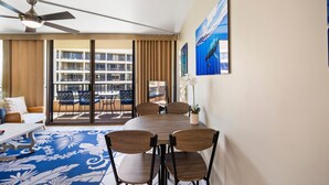 A hotel room with a balcony, a dining area with a table and chairs, and a ceiling fan. - Sugar Beach Resort, #409 1 Bedroom Condo by RedAwning (Kihei)