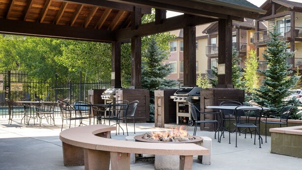 Patio esterno con focolare, posti a sedere e barbecue.