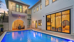 A modern house with a swimming pool, a covered patio, and a large glass door leading to a living area. - Luxury Seagrove w Pool, Hot Tub, Golf Cart & Bikes, Elevator (Seagrove Beach)