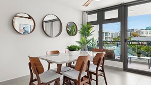 A modern dining area with a large table, wooden chairs, and three round mirrors on the wall. - Stunning New 3/2 Condo, near Beach & SJ Airport. 2 Pools, WiFi, AC  (Carolina)