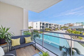 Ein Balkon mit Pool, Sitzgelegenheit und Topfpflanzen.