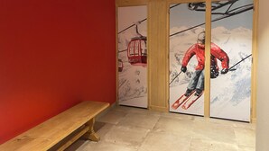 A room with a wooden bench, a ski-themed mural, and a red wall. - 71m² apartment near Megève, 180m from 🚠 La Princesse, parking, ski room (Demi-Quartier)