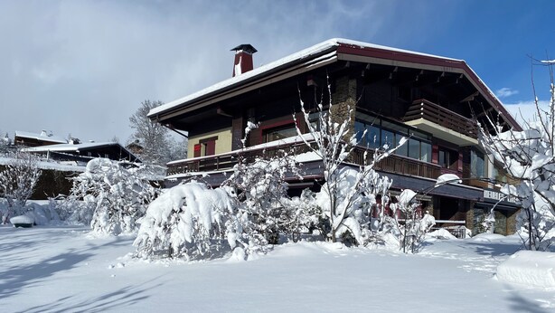 A snow-covered building with a stone facade and wooden balconies. - 71m² apartment near Megève, 180m from 🚠 La Princesse, parking, ski room (Demi-Quartier)