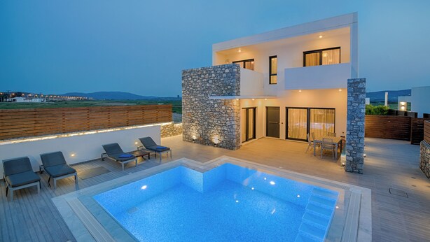 Uma casa moderna de dois andares com piscina, área de estar externa e fachada de pedra.