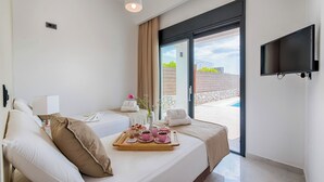 Une chambre d’hôtel avec un lit, une télévision, un plateau avec de la nourriture et une vue sur l’extérieur.