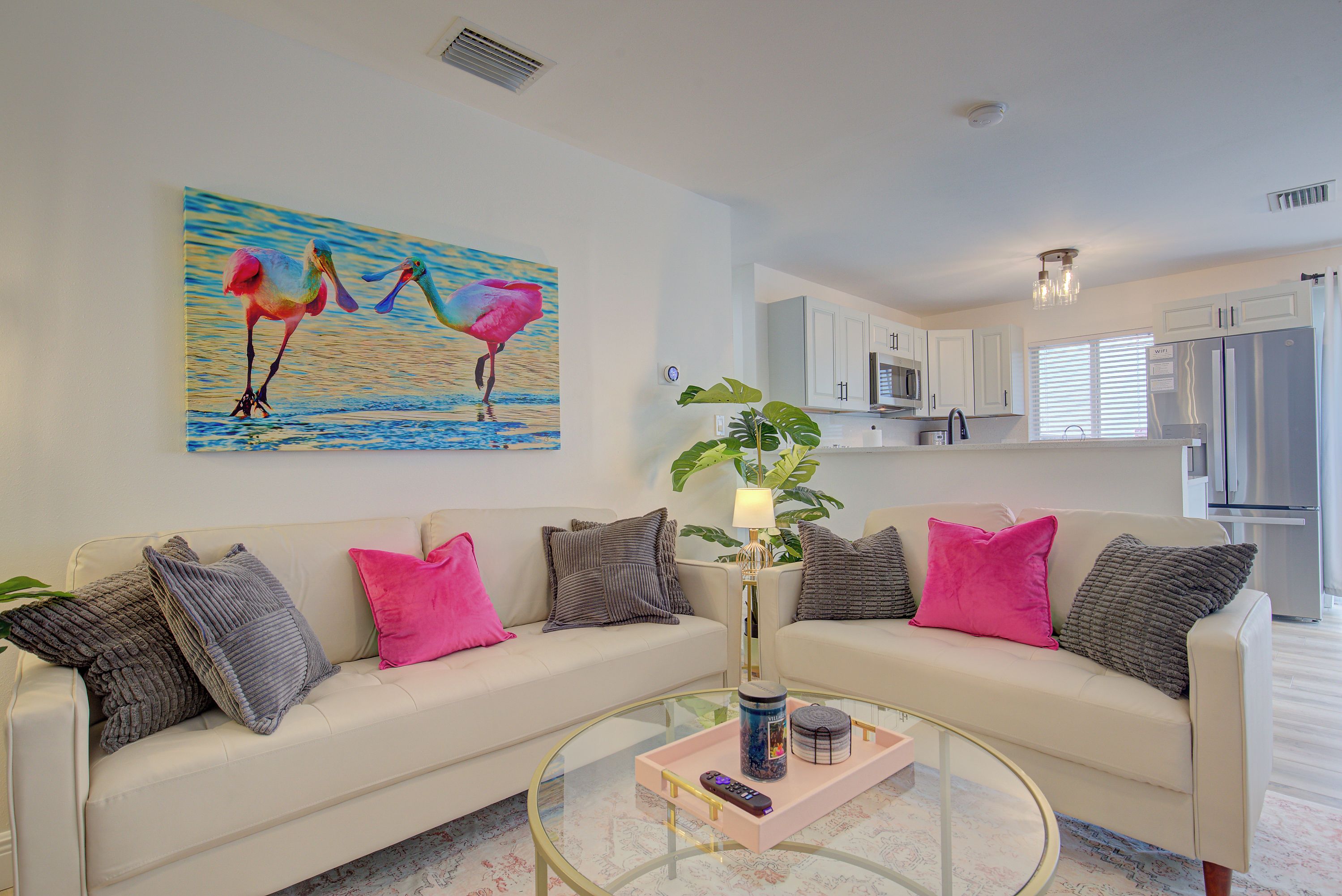 Ein modernes Wohnzimmer mit einer Couch, einem Couchtisch und einem Flamingo-Gemälde.