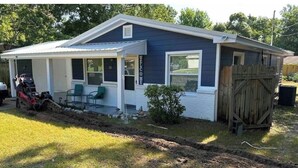 A single-story house with a covered porch, a small front yard, and a wooden fence. - Cozy 3-bedroom house in gorgeous Fort Walton Beach with WiFi, AC all amenities  (Fort Walton Beach)