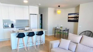 Un appartement moderne comprenant une cuisine, un coin repas et un salon.
