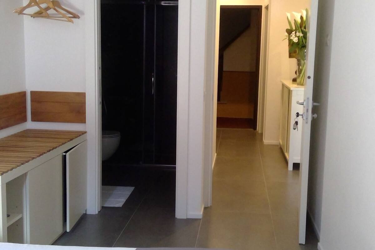 Habitación de hotel con cama, escritorio, armario y baño.