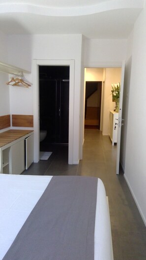 A hotel room with a bed, a desk, a wardrobe, and a bathroom. - OBLO' PORTOVENERE GUESTHOUSE (Portovenere)