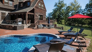 A wooden house with a swimming pool and outdoor seating.
