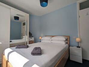 A bedroom with a bed, bedside tables, a wardrobe, and a mirror. - The Pollard Home | Acocks Green (Birmingham)