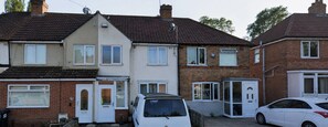 A row of terraced houses with front doors, a satellite dish, and a parked white van. - The Pollard Home | Acocks Green (Birmingham)