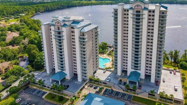 Ein Hochhaus-Hotel mit Pool und Parkplatz.