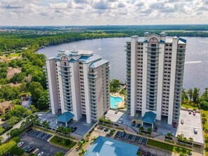 A high-rise hotel with a swimming pool and a parking lot. - Amazing lake view condo with fantastic Disney firework and water sports (Kissimmee)