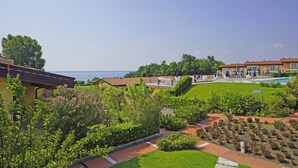 A hotel with a pool, garden, and view of the sea. - Montecolo Resort E7 by Wonderful Italy (Manerba del Garda)