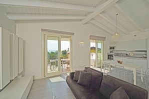 A modern living area with a sofa, dining table, and kitchen.