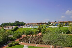 Un hôtel comprenant plusieurs bâtiments, une piscine et des jardins bien entretenus.