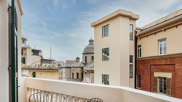 A building with a modern facade, a dome structure in the background, and a balcony with a metal railing. - Brignole Refined Home by Wonderful Italy (Genova)