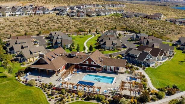 A residential area with houses, a swimming pool, and a well-maintained lawn.