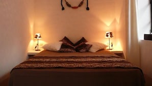 A bedroom with a bed, two bedside tables, and lamps. - Riad La Parenthese (Marrakech)