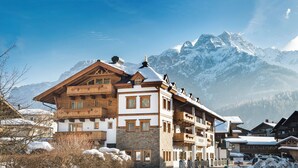 A traditional chalet-style hotel with multiple balconies and a mountain view. - Hotel Sendlhof (Waidring)