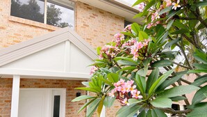 A brick house with a white door and a porch. - Treeview - A Beautiful 3-bed House in Kiama (Kiama)