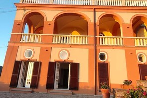 A building with multiple arches, balconies, and circular windows.