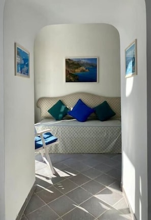 A narrow hallway with a bench, a framed picture on the wall, and a chair. - Charming Location Between Positano and Sorrento (Piano di Sorrento)