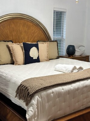 A bed with a wooden headboard, multiple pillows, a white blanket, and a bedside table with a decorative object. -
“Peaceful villa with pool, near lakes, shops & highways – perfect getaway” (Sebring)