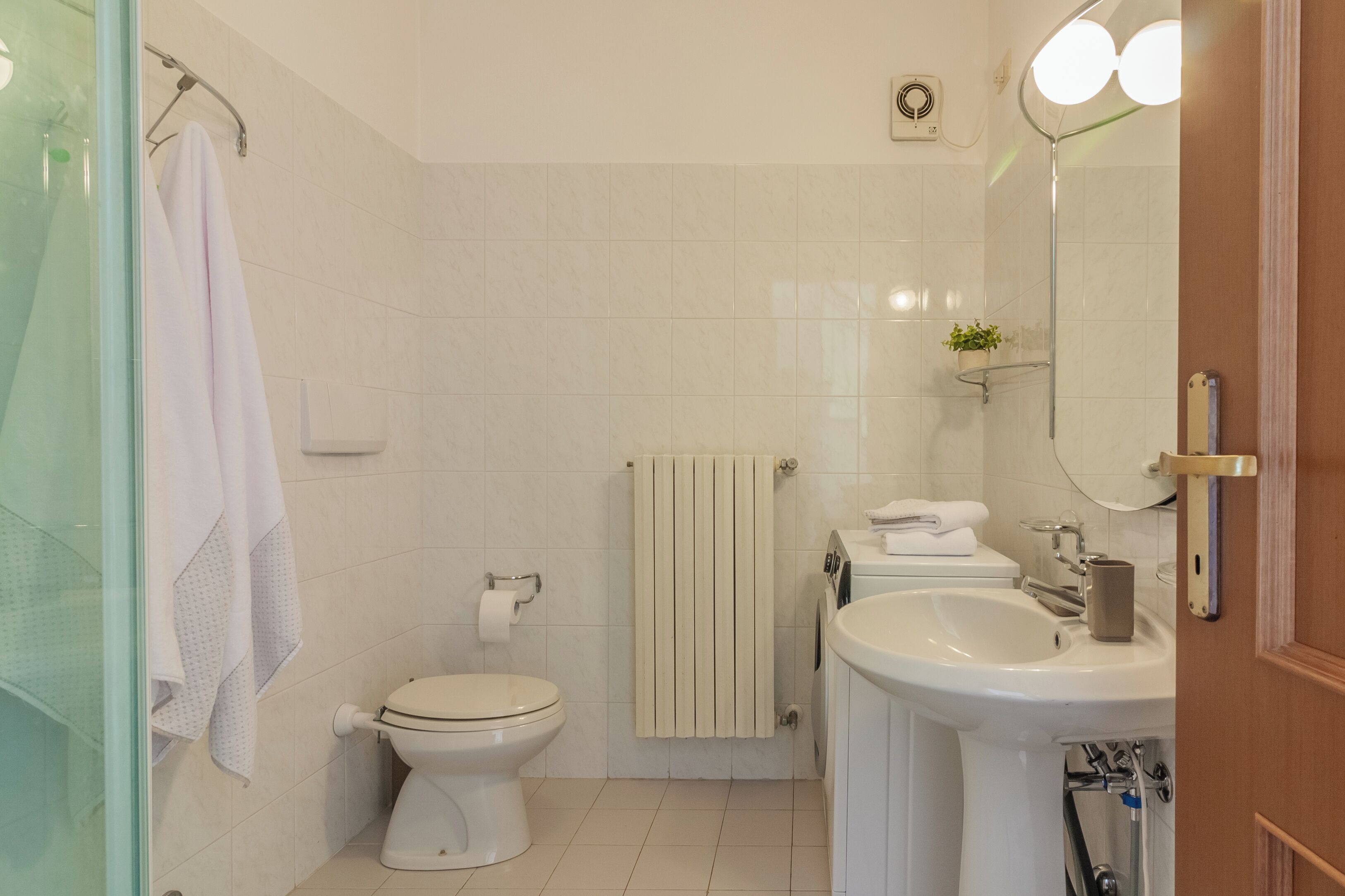 A bathroom with a toilet, sink, and mirror.