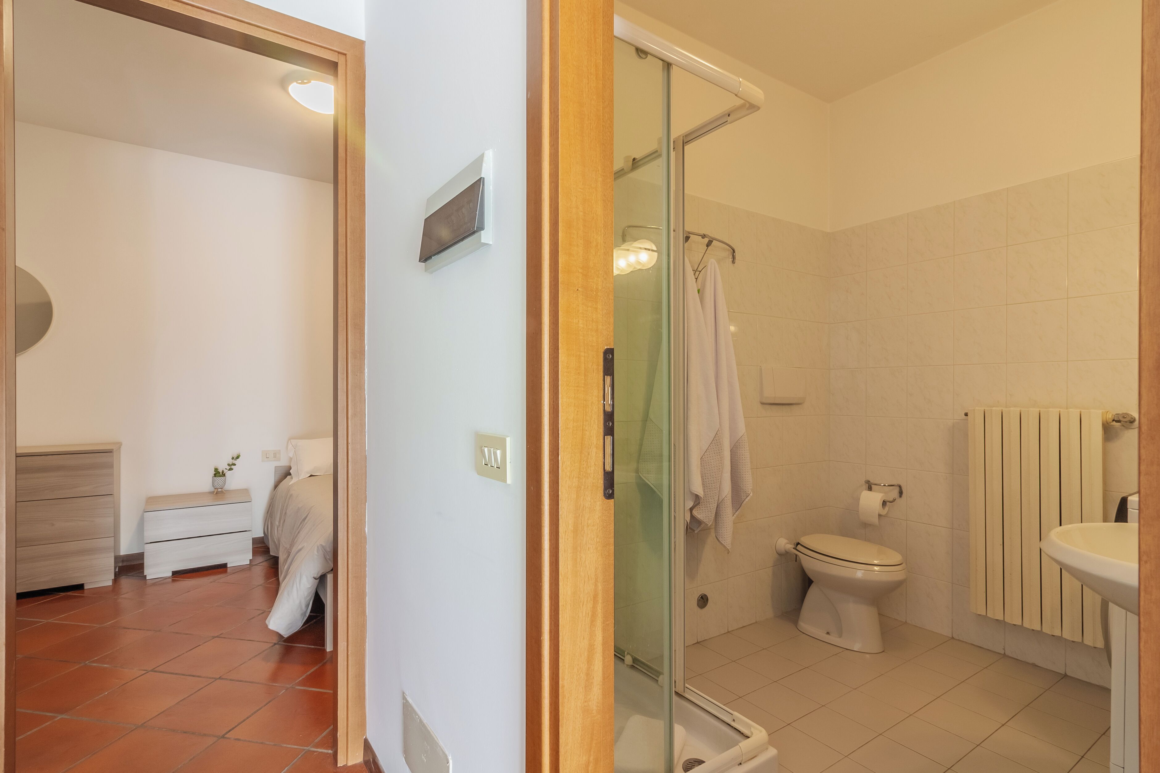 A modern bathroom with a glass shower enclosure, a toilet, and a sink.